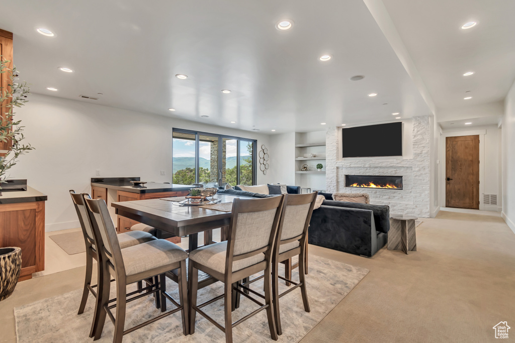 Dining room with recessed lighting, a stone fireplace, and baseboards
