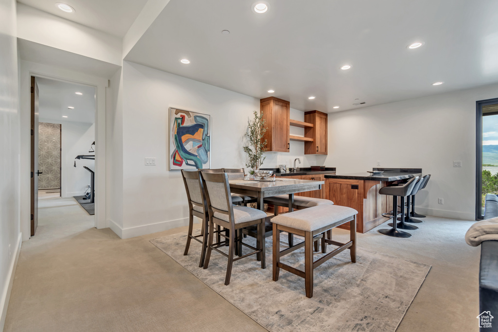 Dining space with light carpet, baseboards, and recessed lighting