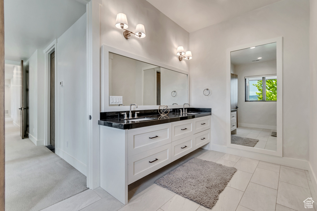 Bathroom with double vanity and baseboards