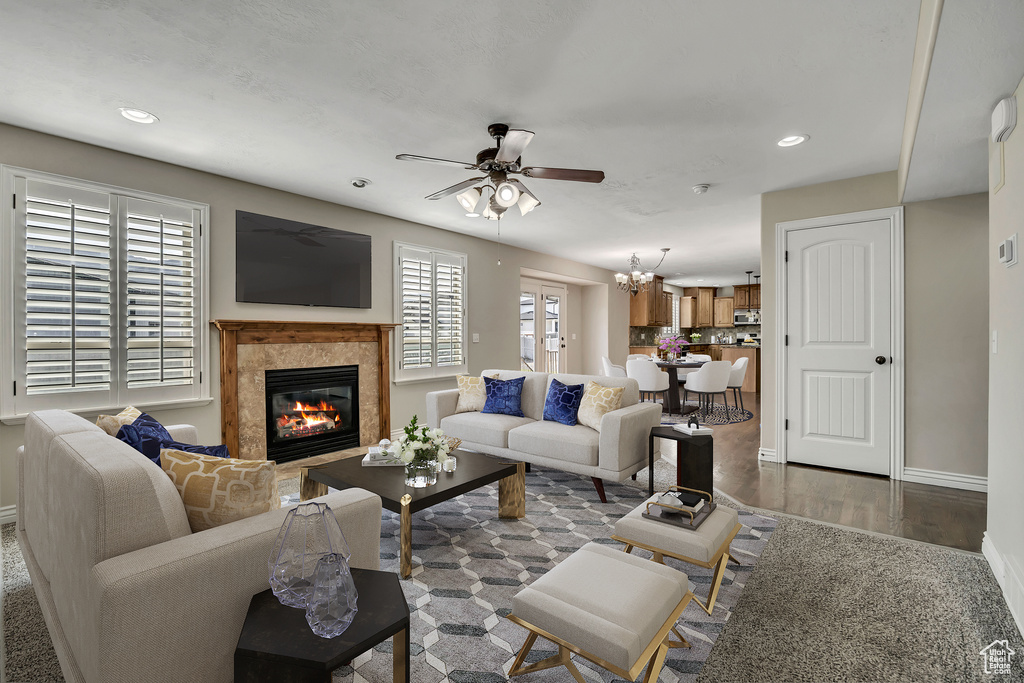 Living room with ceiling fan, baseboards, a premium fireplace, recessed lighting, and wood finished floors