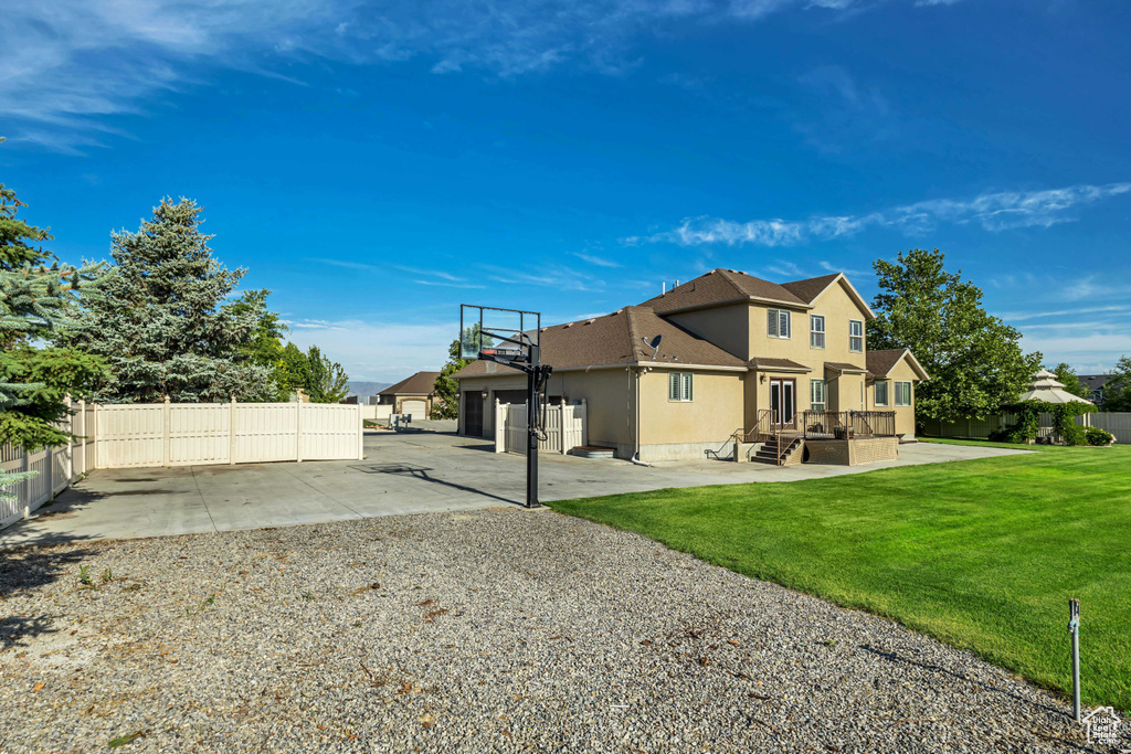 Rear view of property featuring driveway, stucco siding, and an attached garage
