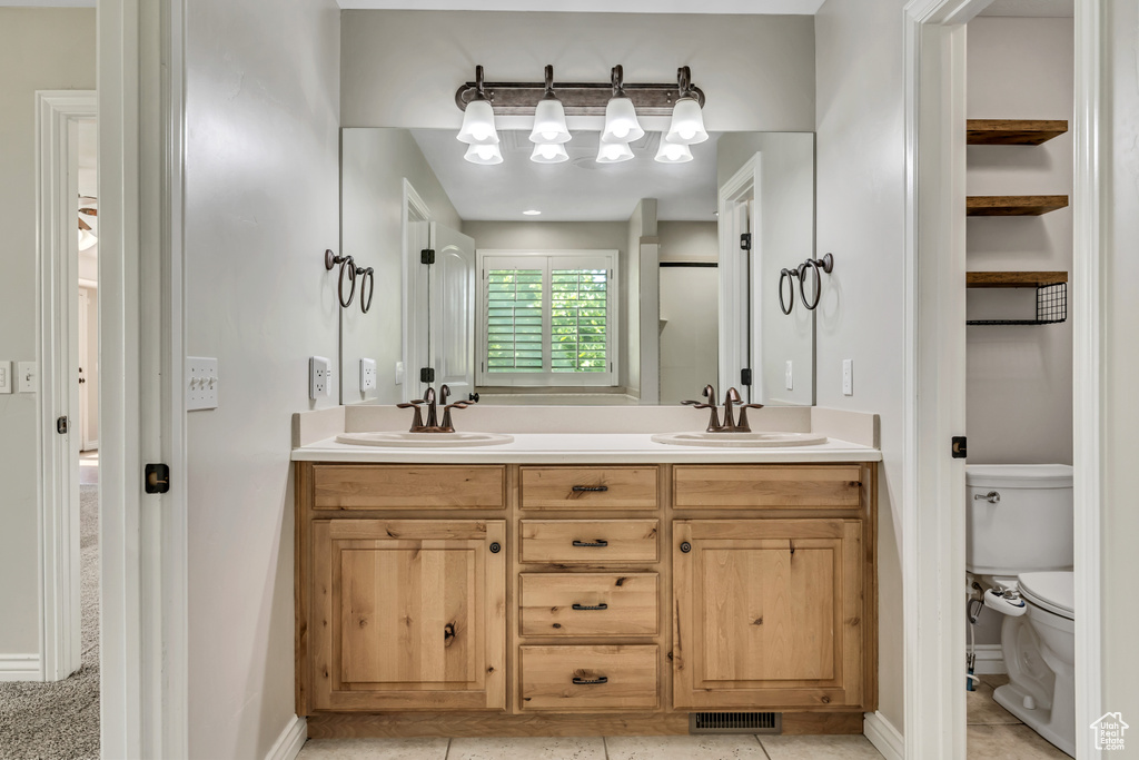 Full bathroom with toilet and double vanity