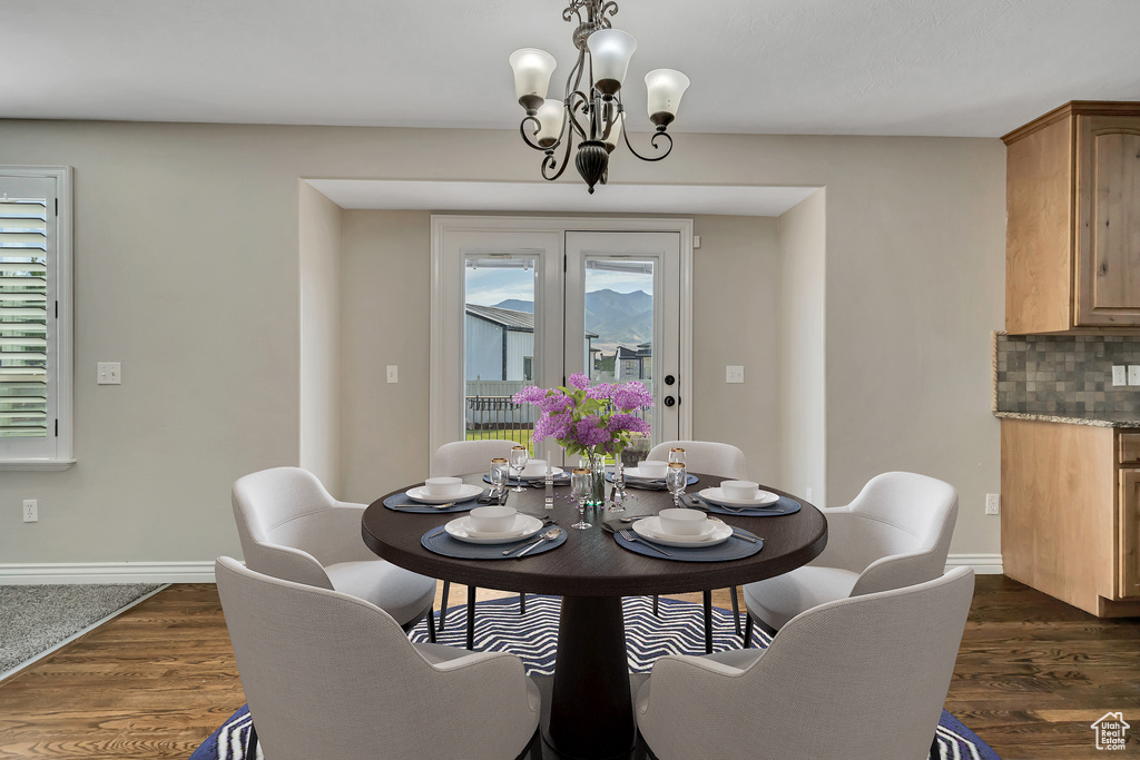 Dining room featuring a chandelier, baseboards, and dark wood-style floors