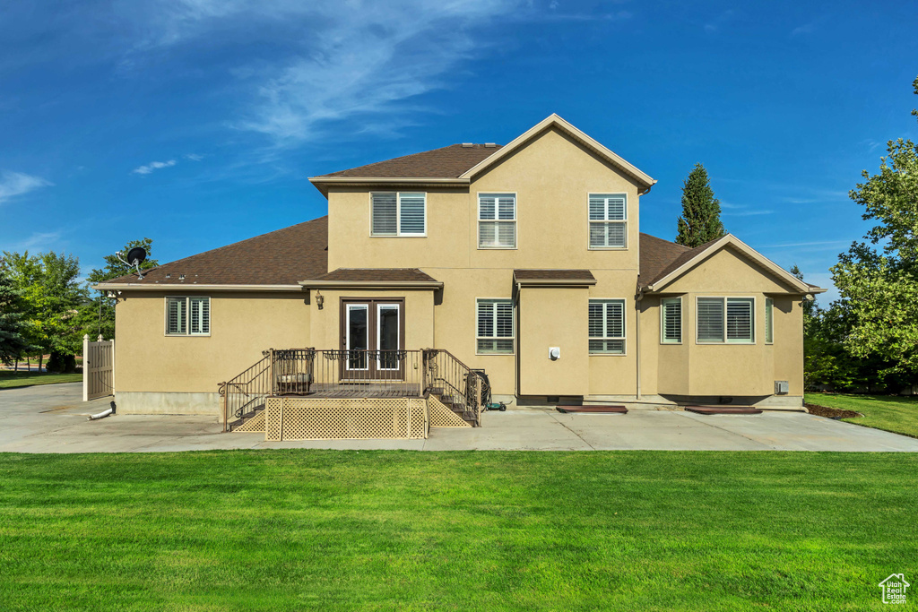 Back of property with stucco siding, french doors, a yard, and a patio