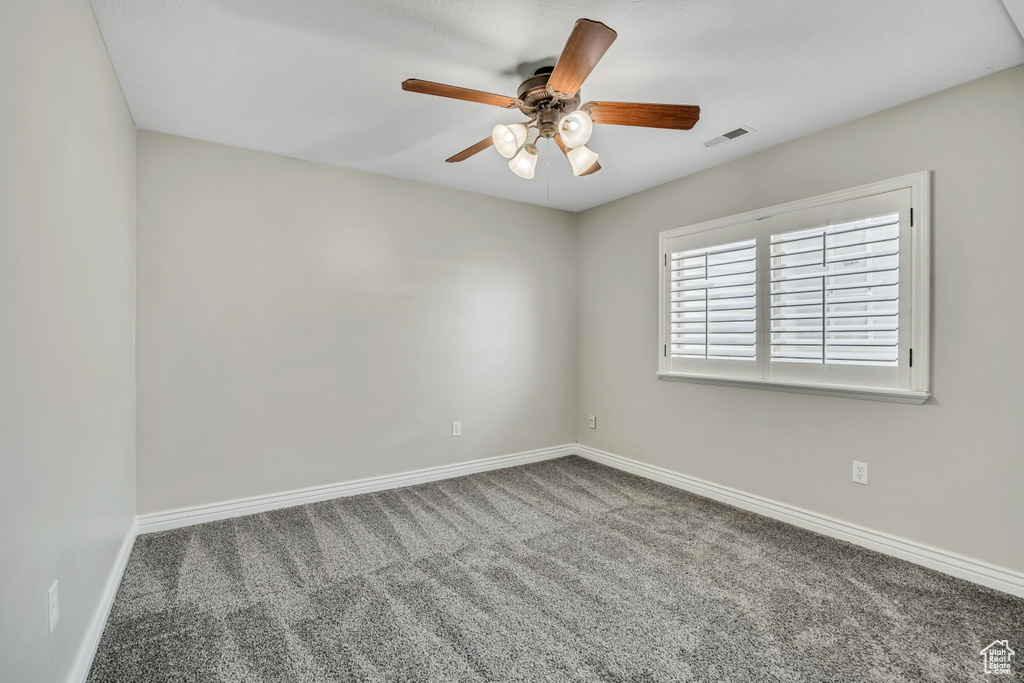 Spare room with carpet flooring, a ceiling fan, and baseboards