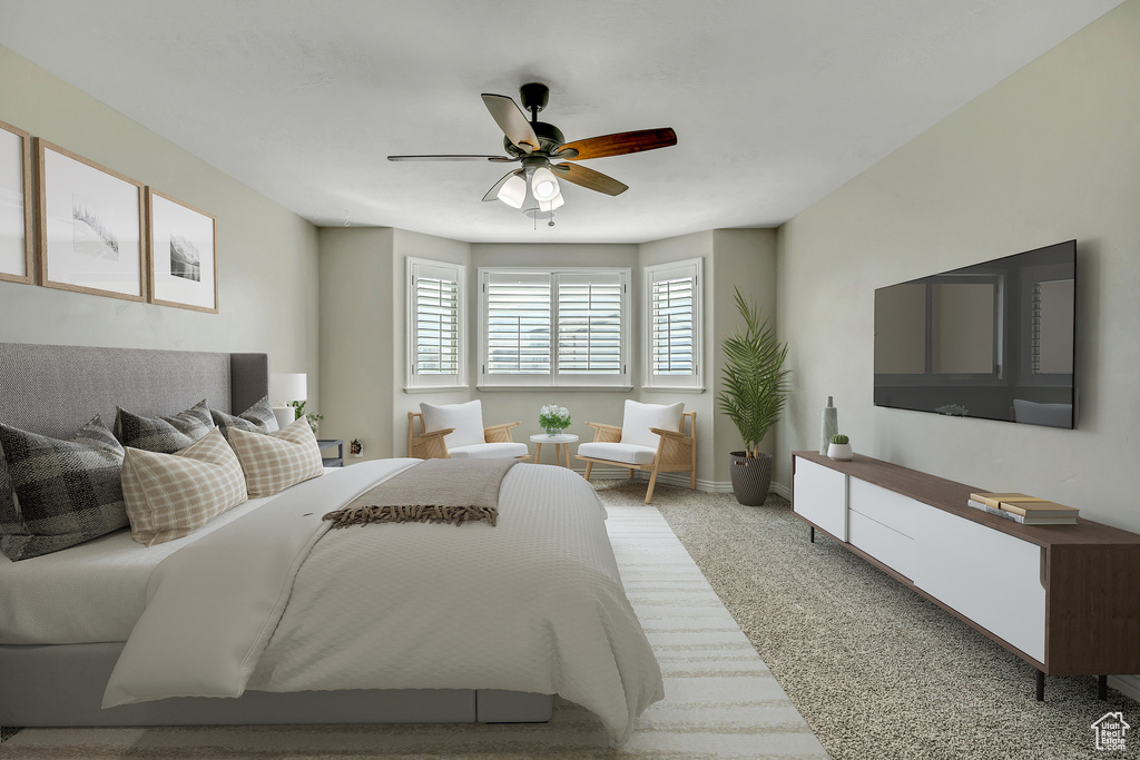 Carpeted bedroom featuring ceiling fan and baseboards