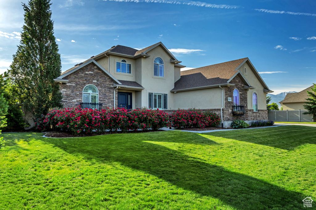 Traditional home with stucco siding, stone siding, and roof with shingles