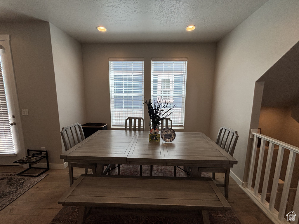 Dining room featuring wood finished floors, recessed lighting, baseboards, and a textured ceiling