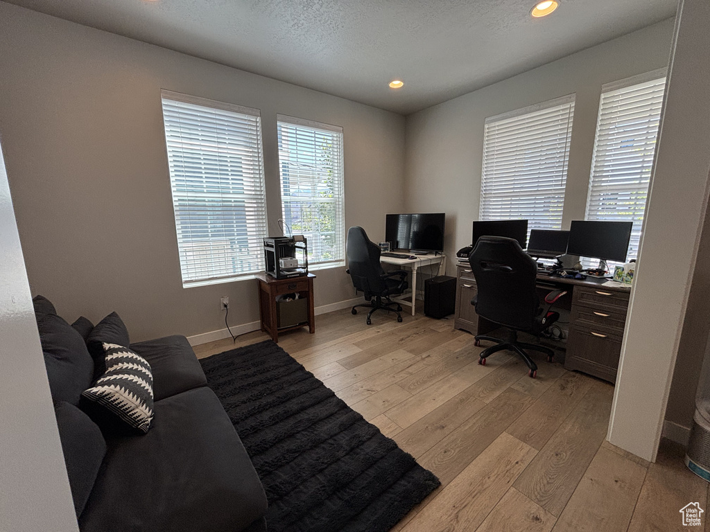 Office with light wood finished floors, baseboards, and recessed lighting