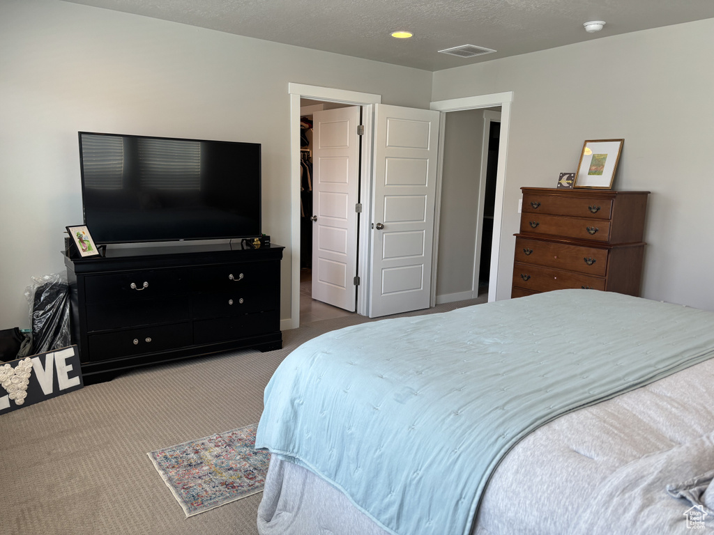 Bedroom with carpet and a walk in closet