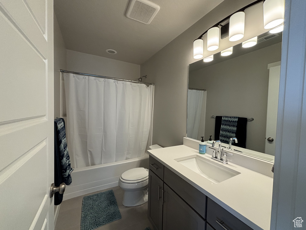 Bathroom with vanity, toilet, and shower / bath combo