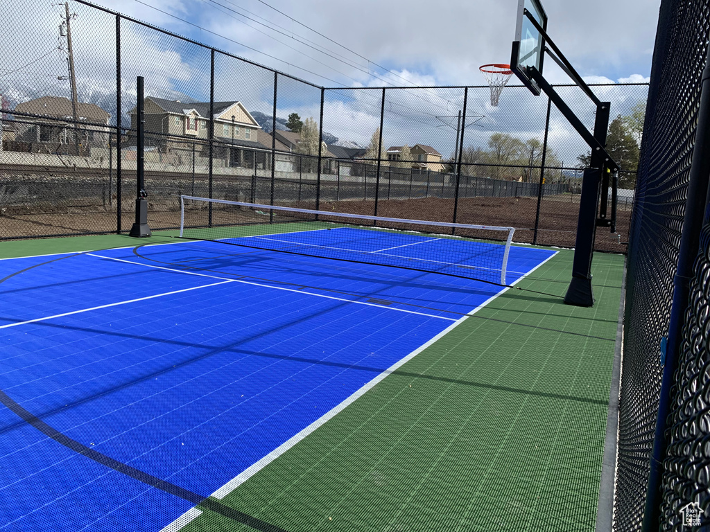 View of tennis court featuring community basketball court and a residential view
