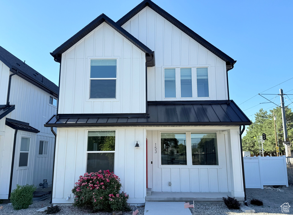 Modern farmhouse style home featuring board and batten siding, a standing seam roof, metal roof, and a porch