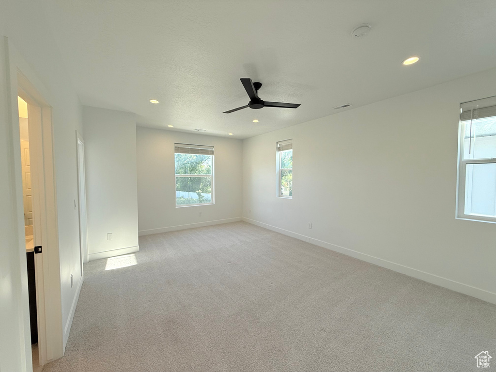 Spare room featuring ceiling fan, baseboards, recessed lighting, light colored carpet, and a smoke detector