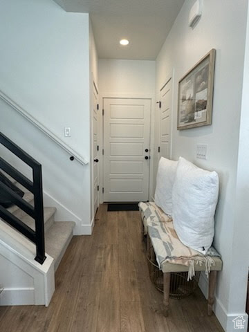 Foyer with baseboards, stairway, wood finished floors, and recessed lighting