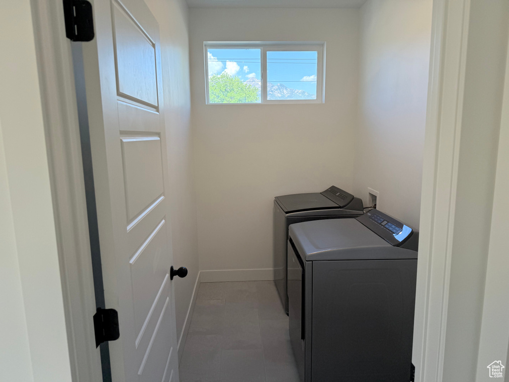 Washroom with washing machine and clothes dryer and baseboards