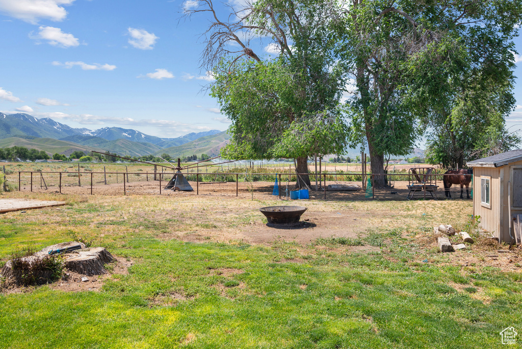 View of yard featuring a mountain view, a fire pit, and a view of countryside