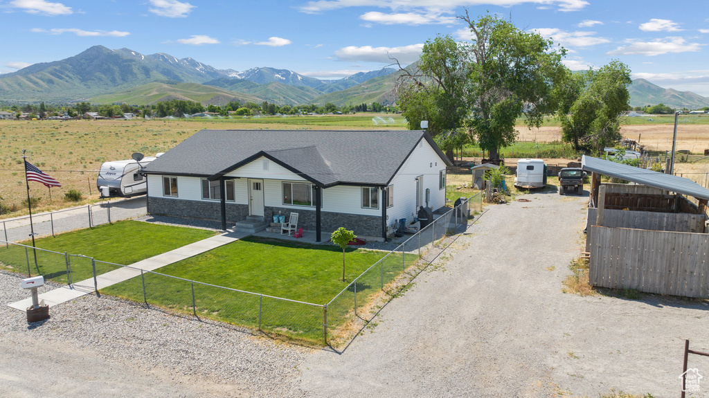 View of front facade featuring a mountain view, stone siding, a view of countryside, and driveway