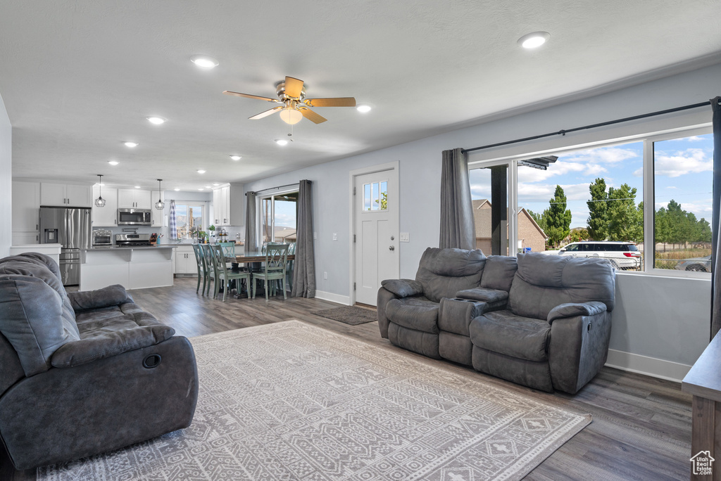 Living area with ceiling fan, wood finished floors, recessed lighting, and baseboards