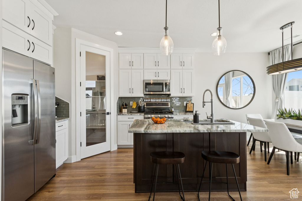 Kitchen featuring stainless steel appliances, a sink, dark wood-style flooring, decorative backsplash, and recessed lighting