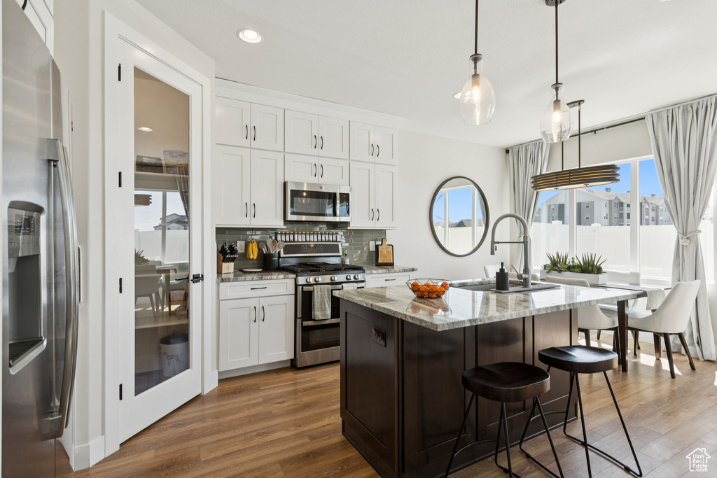 Kitchen with appliances with stainless steel finishes, a sink, healthy amount of natural light, tasteful backsplash, and recessed lighting