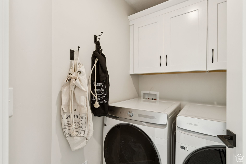 Washroom featuring washing machine and clothes dryer and cabinet space