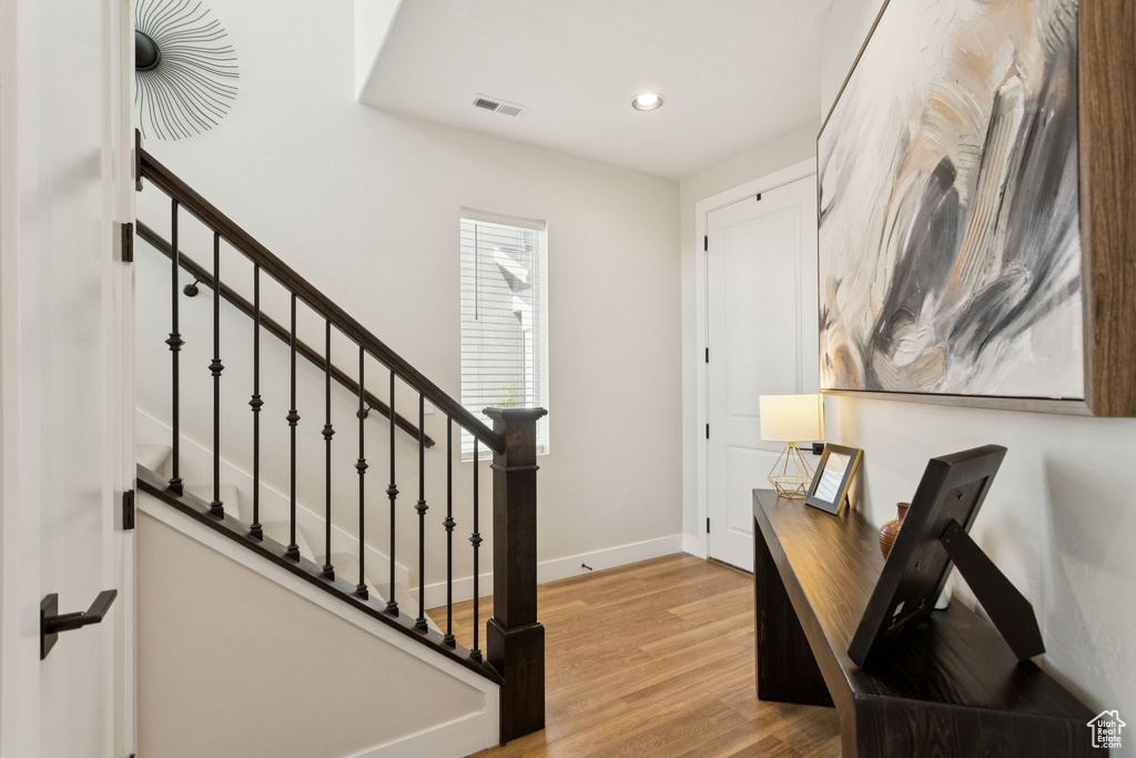Entryway featuring wood finished floors, baseboards, recessed lighting, and stairs