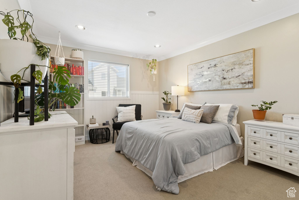 Bedroom with wainscoting, light carpet, and recessed lighting