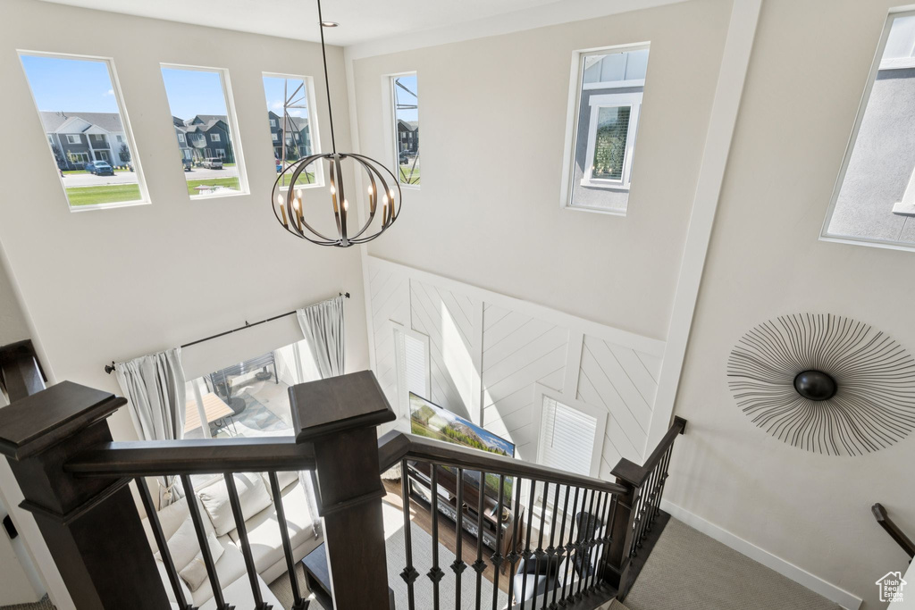 Staircase with a chandelier, carpet, and baseboards