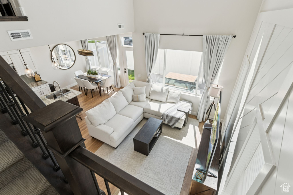 Living room with wood finished floors, a high ceiling, and baseboards