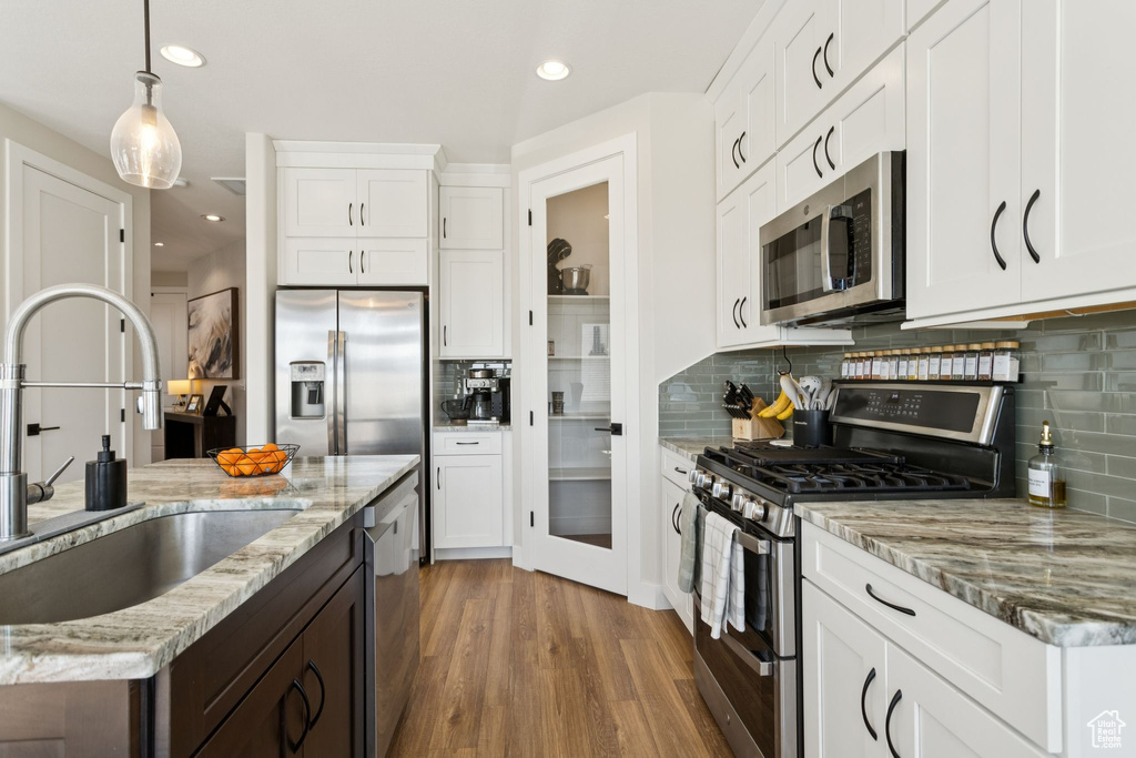Kitchen featuring appliances with stainless steel finishes, a sink, dark wood-style floors, decorative backsplash, and recessed lighting