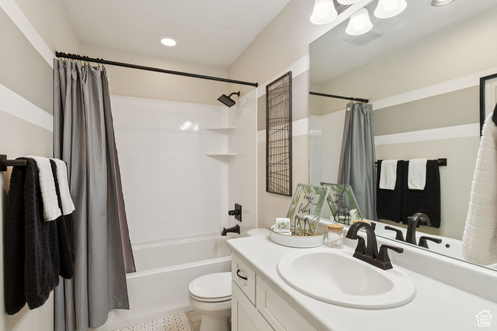 Bathroom with shower / bath combo with shower curtain, vanity, toilet, and recessed lighting