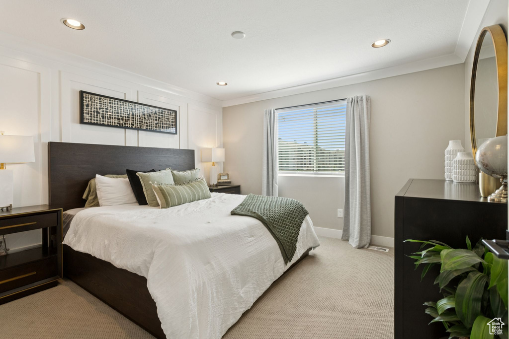 Bedroom with crown molding, light colored carpet, recessed lighting, and baseboards