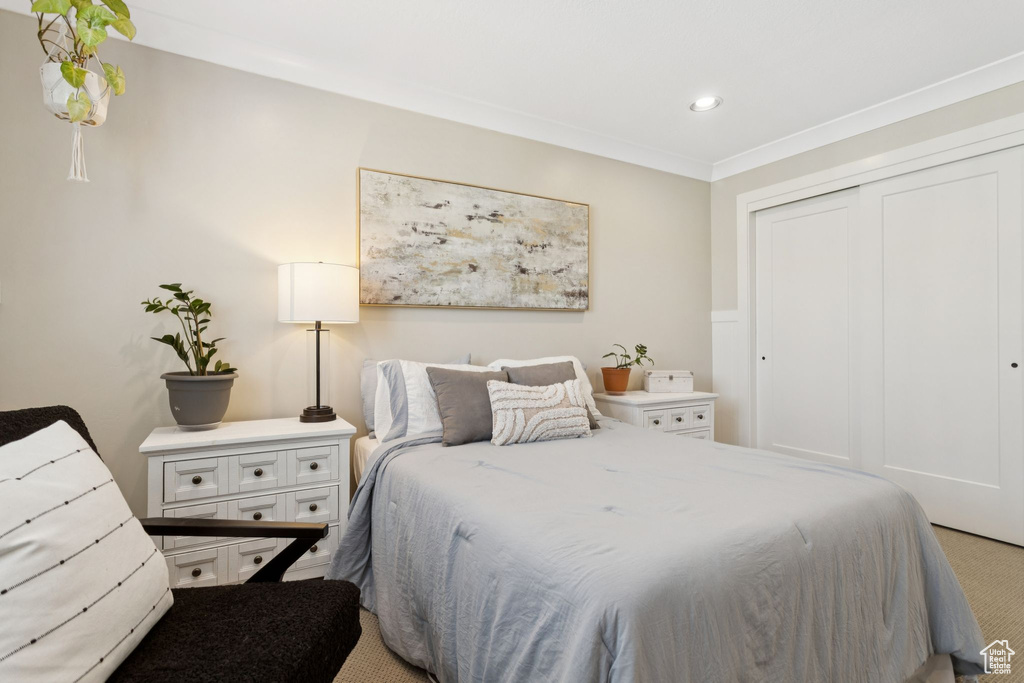 Carpeted bedroom with a closet, recessed lighting, and ornamental molding