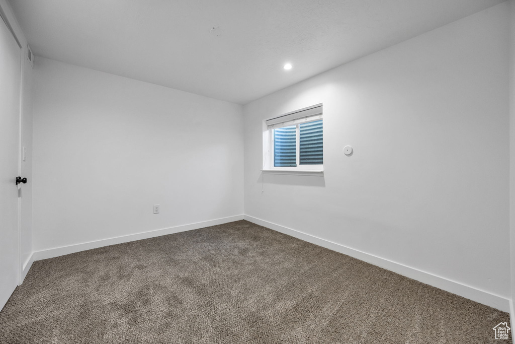 Unfurnished room featuring dark carpet, recessed lighting, and baseboards