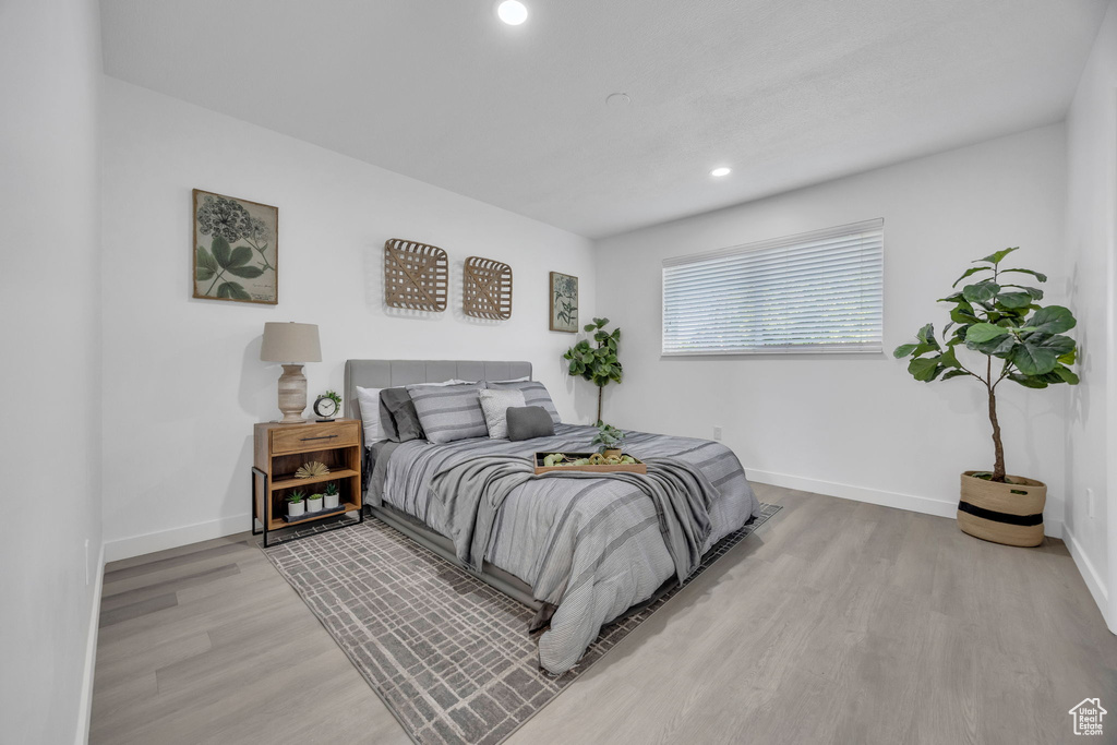 Bedroom featuring light wood-type flooring, baseboards, and recessed lighting
