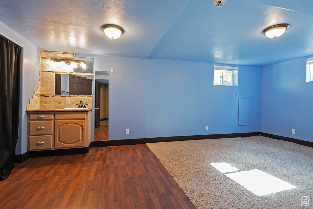 Interior space with baseboards, dark wood-type flooring, and a sink