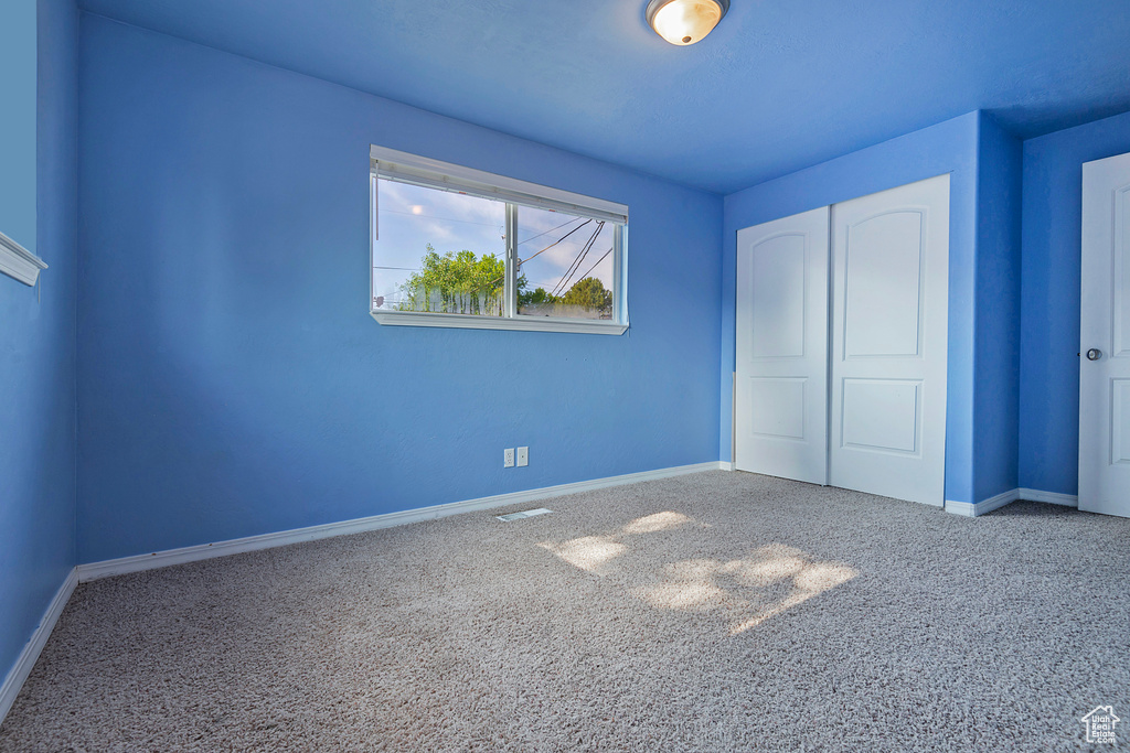 Unfurnished bedroom featuring carpet flooring, a closet, and baseboards