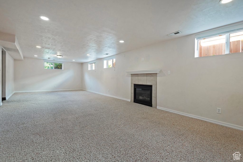 Basement featuring recessed lighting, a tiled fireplace, carpet, and baseboards