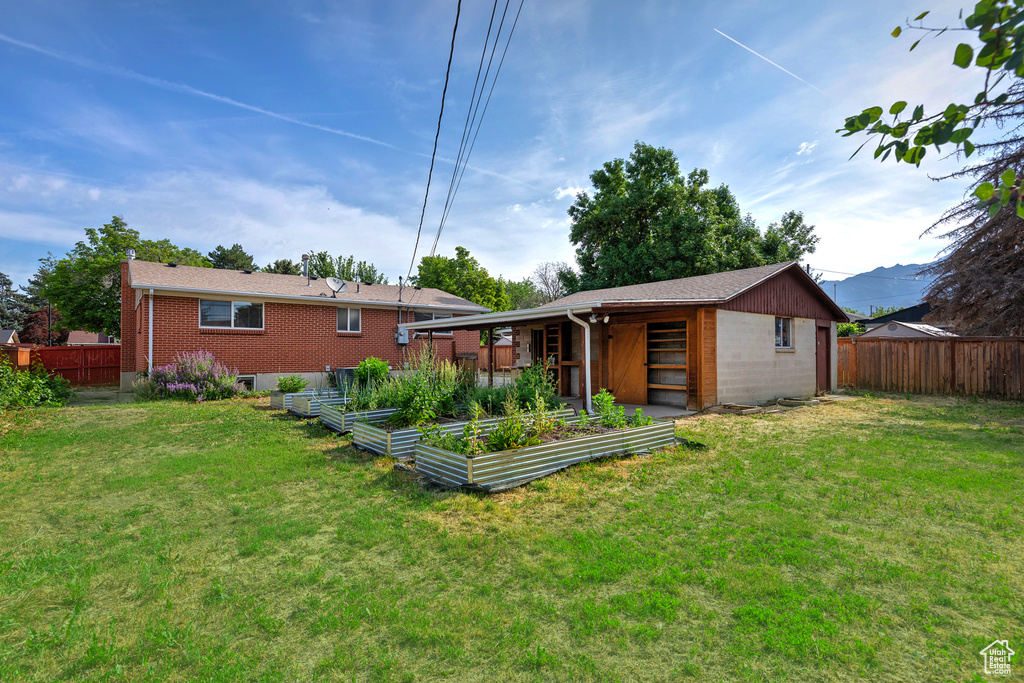 Rear view of property featuring a vegetable garden and brick siding