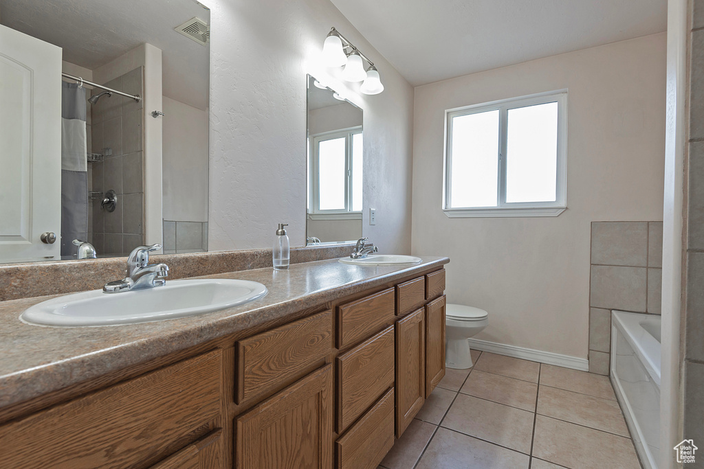 Full bathroom featuring toilet, double vanity, tile patterned floors, a tub, and a shower with curtain