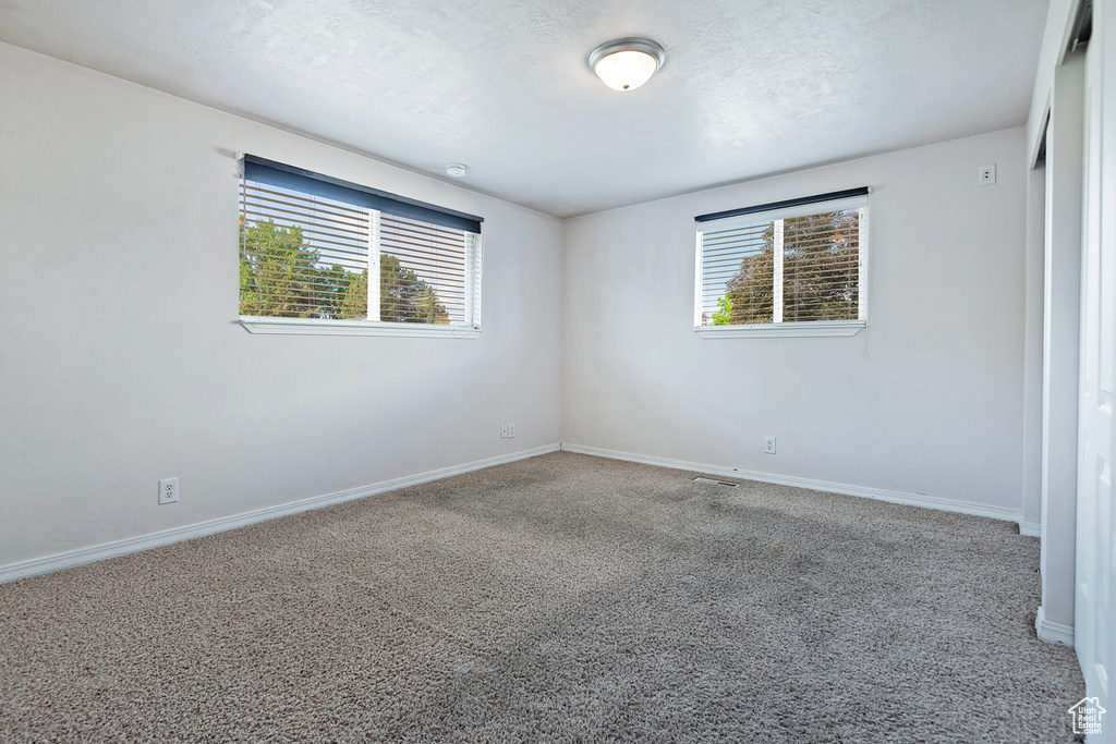 Spare room with carpet and baseboards