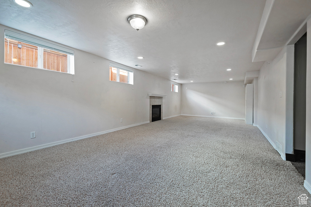 Below grade area featuring recessed lighting, carpet floors, a tile fireplace, and baseboards