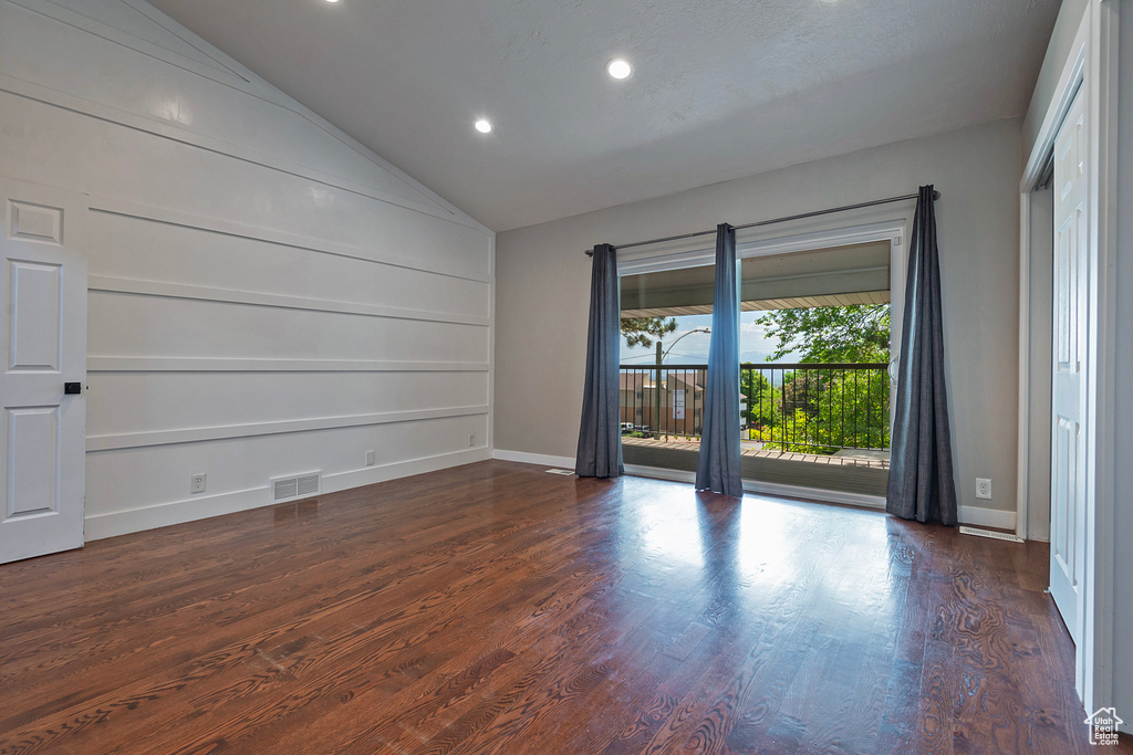 Empty room with dark wood finished floors, recessed lighting, lofted ceiling, baseboards, and built in features