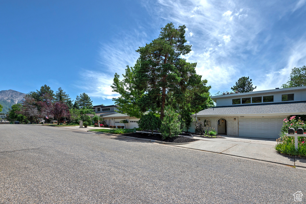 View of front facade with driveway, a mountain view, and brick siding