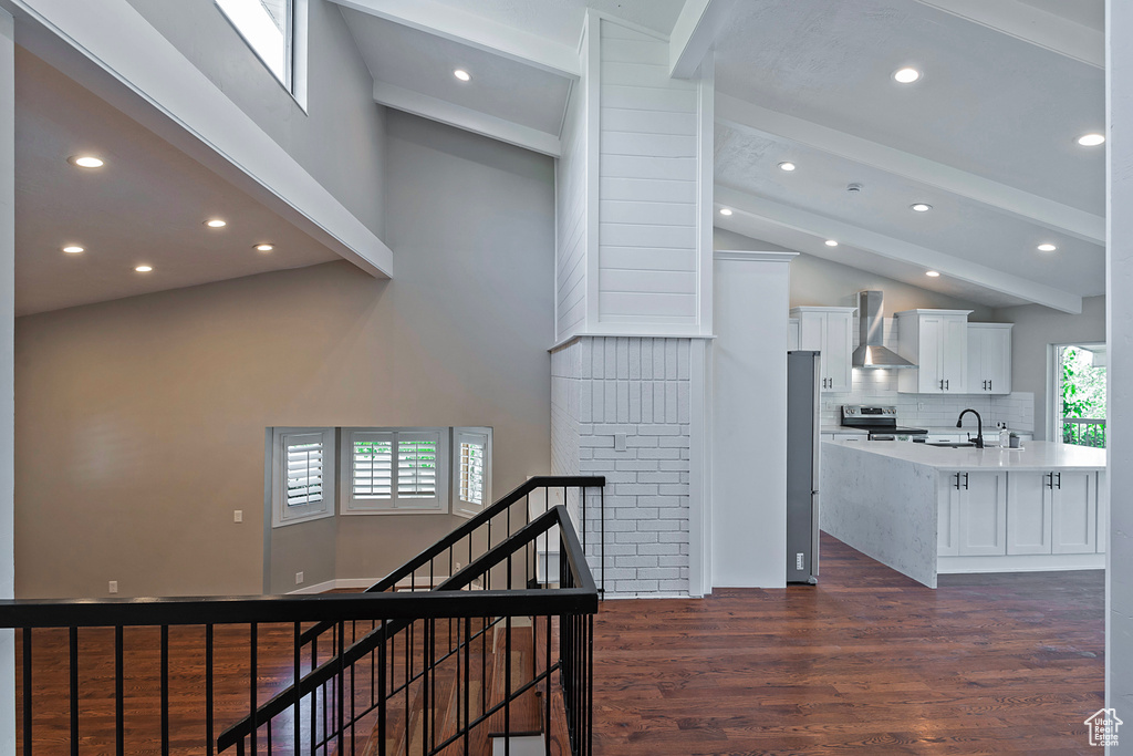 Hallway featuring high vaulted ceiling, a sink, beam ceiling, recessed lighting, and dark wood finished floors