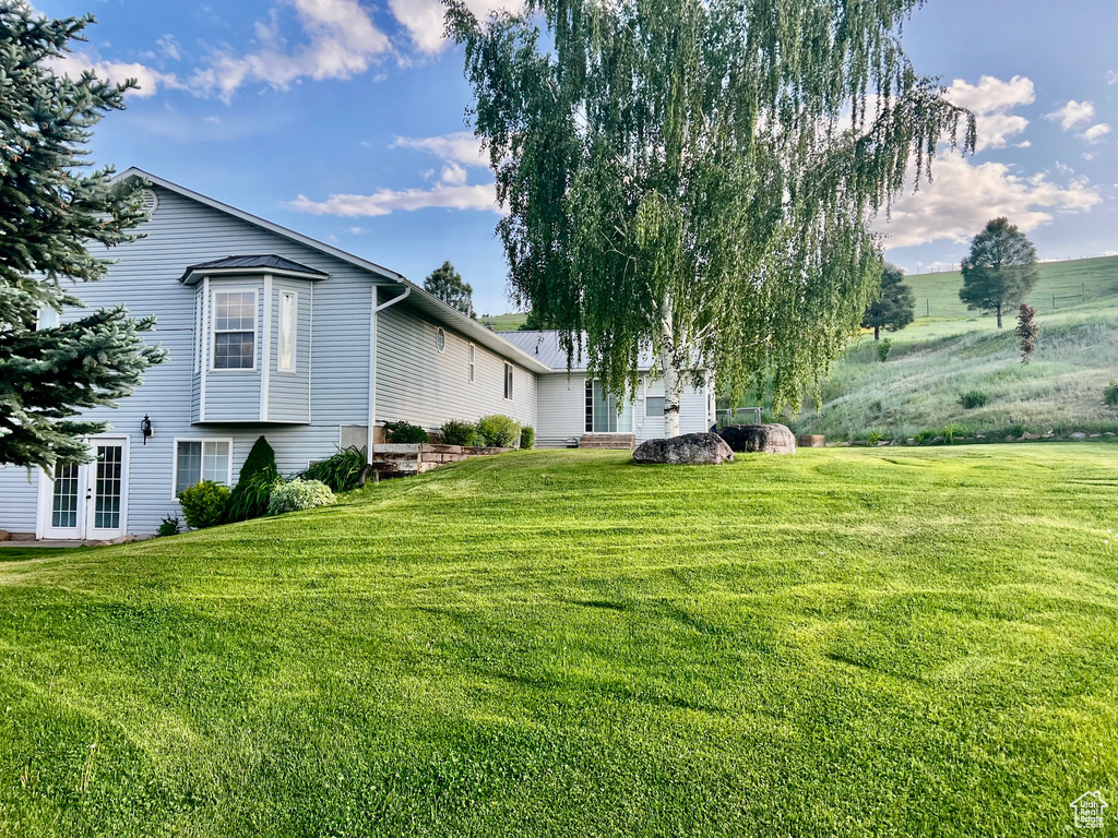 View of green lawn featuring french doors