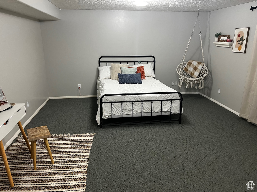 Bedroom featuring carpet flooring, a textured ceiling, and baseboards