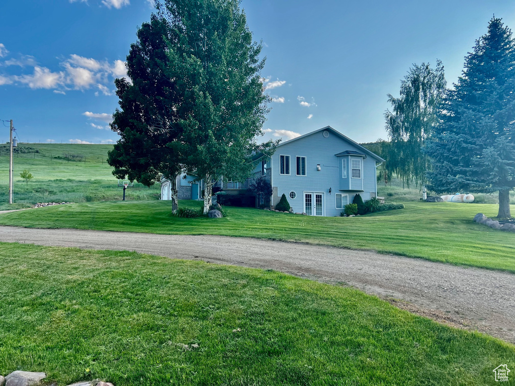 View of side of property with a lawn