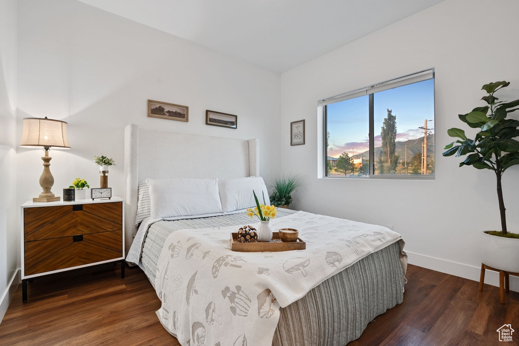 Bedroom with dark wood-type flooring and baseboards